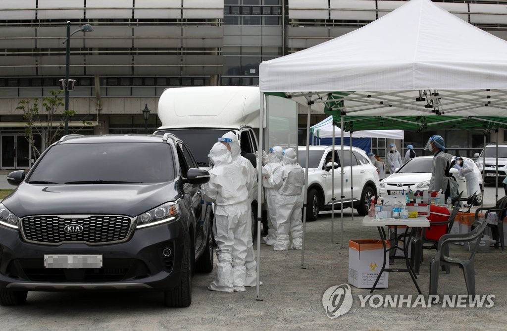 Medical staff conduct COVID-19 diagnostic tests at a drive-thru testing site in Damyang, 350 kilometers south of Seoul, on April 16, 2021. (Yonhap)