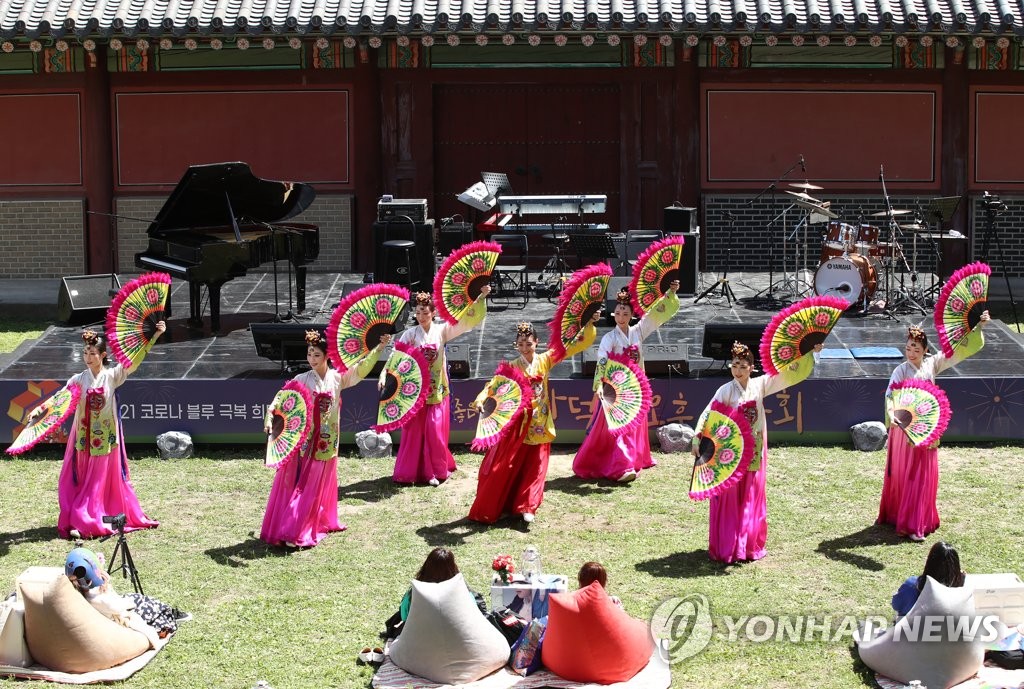 People enjoy a Korean fan dance performance at Changdeok Palace in Seoul amid the COVID-19 pandemic on May 9, 2021. (Yonhap)