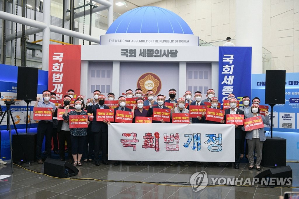 This June 23, 2021, file photo, provided by the Sejong City National Balanced Development Support Center, shows Sejong Mayor Lee Choon-hee and other city officials calling for revision of the National Assembly Act to open a parliament branch in the administrative city, about 120 kilometers south of Seoul, in the Sejong City Hall lobby.