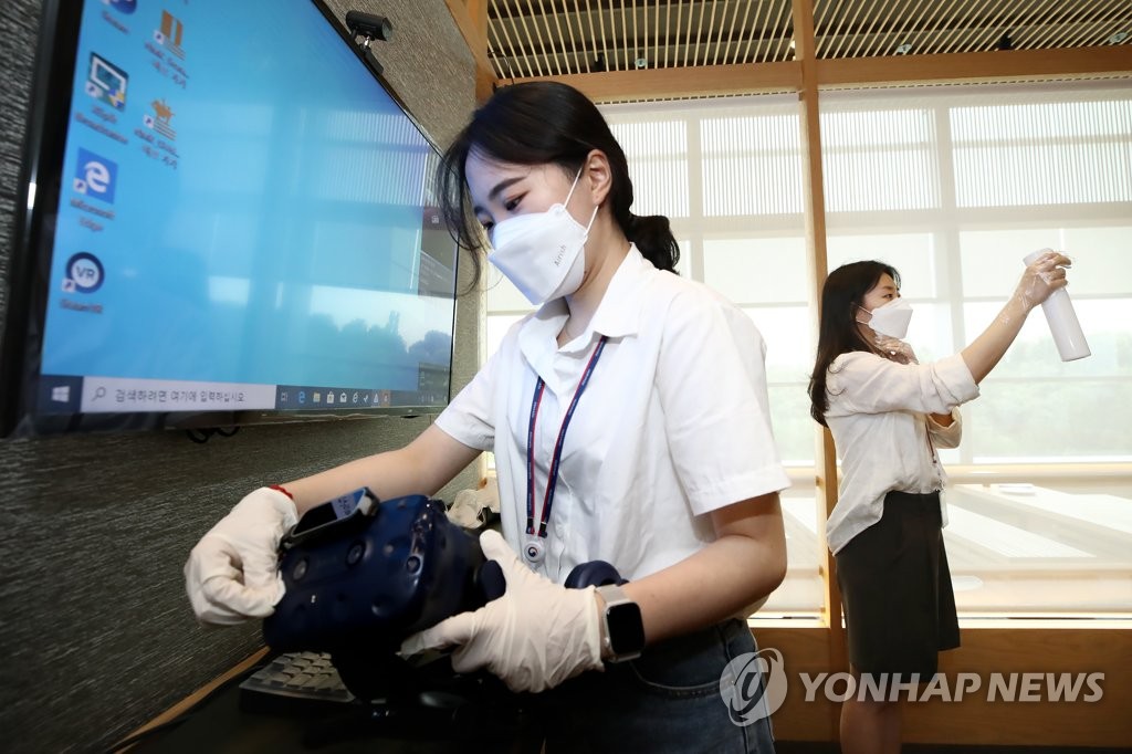 Health workers disinfect virtual reality headsets at the National Museum of Korea in central Seoul on July 12, 2021. (Yonhap)