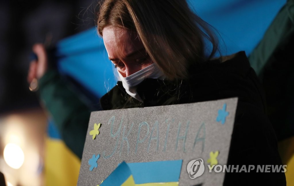 A Ukrainian woman holds a sign during a rally against Russia's invasion of her country in the southeastern port city of Busan on Feb. 28, 2022. (Yonhap)