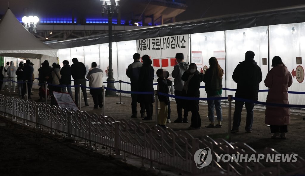 People wait in line to receive tests at a COVID-19 testing station in western Seoul on March 11, 2022. (Yonhap)