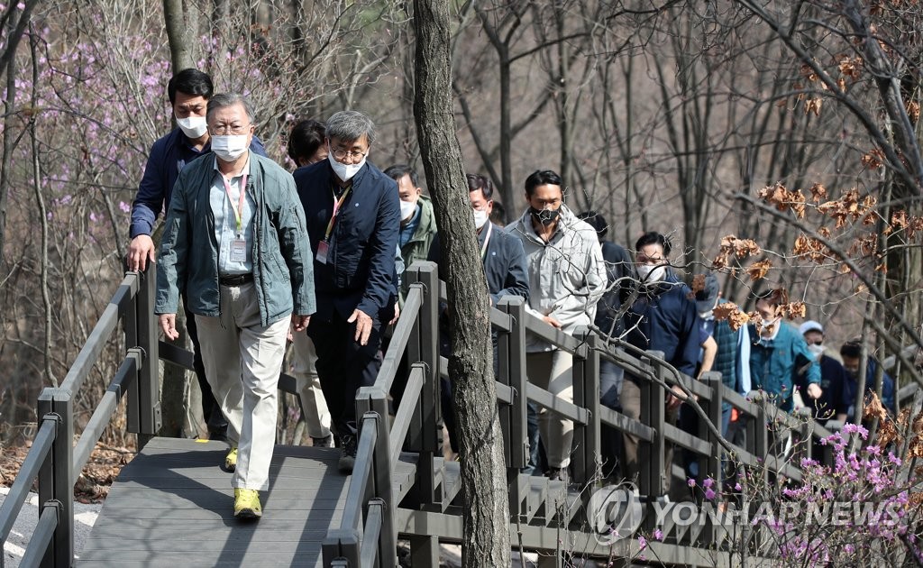 President Moon Jae-in (front) treks along the southern side of Mount Bukak in Seoul on April 5, 2022. (Yonhap)