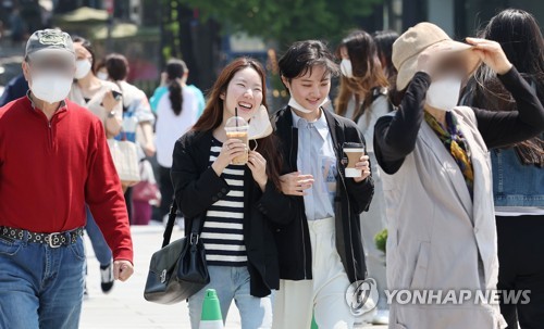 Unas estudiantes sin mascarillas se dirigen a sus clases en la Universidad Femenina Ewha, en Seúl, el 3 de mayo de 2022, tras el levantamiento del uso obligatorio de mascarillas al aire libre.