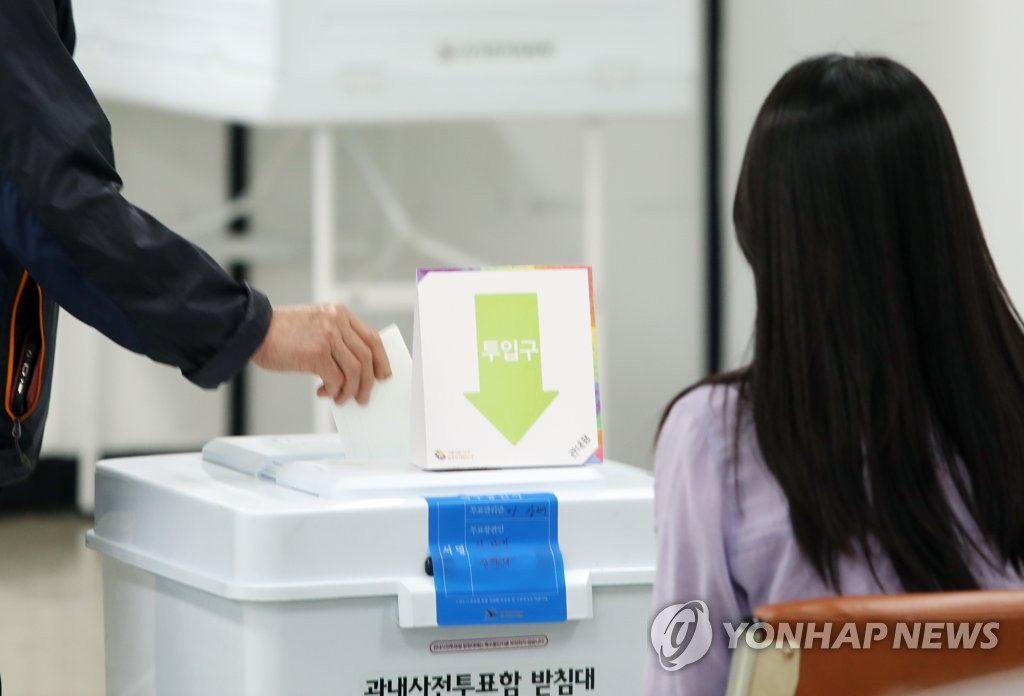 A voter casts ballots at a polling station in Daegu on May 27, 2022, the first day of two-day early voting for the June 1 local elections and parliamentary by-elections. (Yonhap)