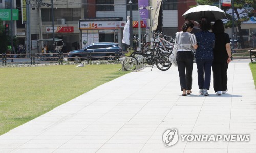 양산 아래서 더위 피하는 시민들