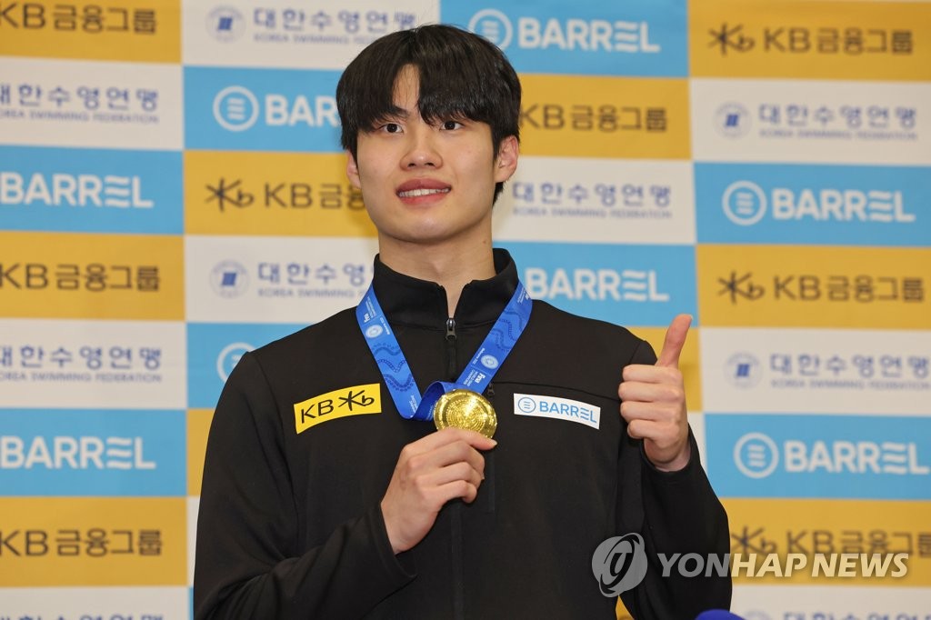 In this file photo from Dec. 20, 2022, South Korean swimmer Hwang Sun-woo poses with his gold medal from the men's 200-meter freestyle at the FINA Short Course World Swimming Championships after arriving at Incheon International Airport, just west of Seoul. (Yonhap)