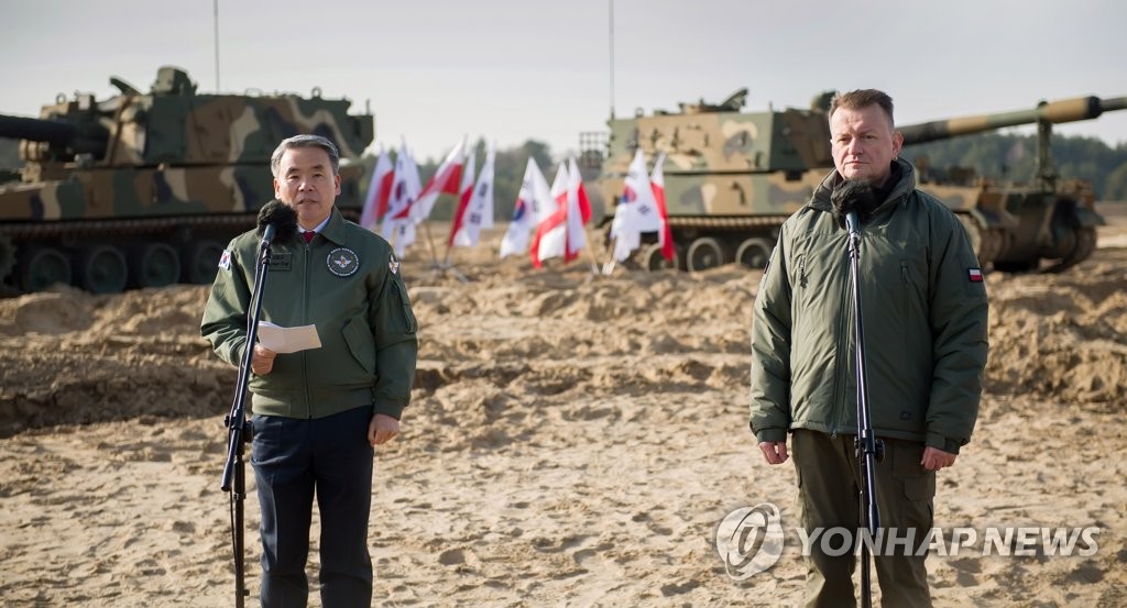 Defense Minister Lee Jong-sup (L) and his Polish counterpart, Mariusz Blaszczak, attend a test firing of K9 self-propelled howitzers at an artillery range in Torun, Poland, on Feb. 23, 2023, in this photo provided by Lee's office the next day. (PHOTO NOT FOR SALE) (Yonhap)