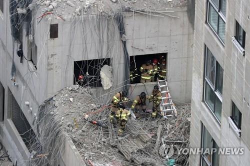 انتشال جثة أحد العمال المفقودين في موقع انهيار المبنى السكني في مدينة كوانغجو - 1
