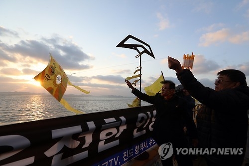 A family member of a victim flies a kite at Paengmok Harbor on Jan. 9, 2017, wishing for his brother's return on the 1,000th day since the ferry Sewol sank. (Yonhap)