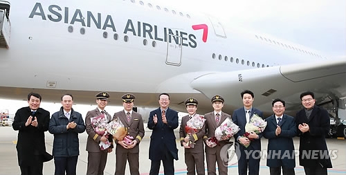 This file photo, taken on Dec. 25, 2016, shows Asiana Airlines officials celebrating the start of new flight services by the new Airbus A380 aircraft. (Yonhap)
