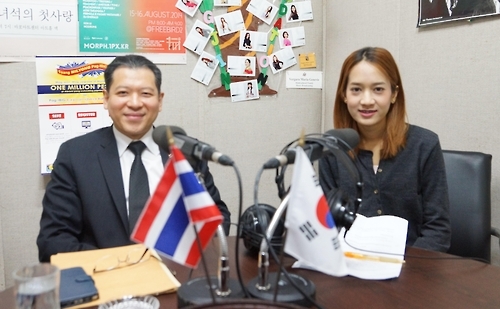 Thai Ambassador to South Korea Sarun Charoensuwan (L) poses with a newscaster during a special program on the occasion of the 9th anniversary of the Multicultural Family Music Broadcast in Seoul on Jan. 17, 2017. (Yonhap) 