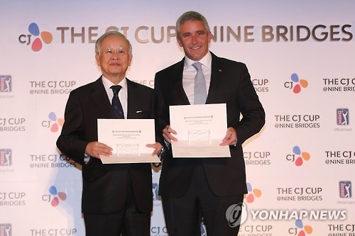 In this file photo taken on Oct. 24, 2016, Sohn Kyung-shik, chairman of CJ Group (L), and Jay Monahan, then deputy commissioner of the PGA Tour, pose with their agreements in Seoul after CJ signed on to host the CJ Cup@Nine Bridges, the first PGA Tour event in South Korea. (Yonhap)