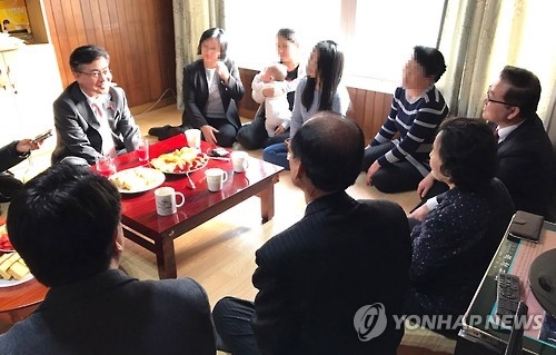 In this photo provided by the Ministry of Unification on Jan. 20, 2017, Unification Minister Hong Yong-pyo (L) talks with North Korean defectors at a shelter in an undisclosed location in South Korea. (Yonhap)