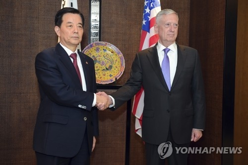 South Korean Defense Minister Han Min-koo (L) shakes hands with U.S. Secretary of Defense Jim Mattis in their meeting held on the sidelines of the 16th Asia Security Summit in Singapore on June 3, 2017. (AP-Yonhap)