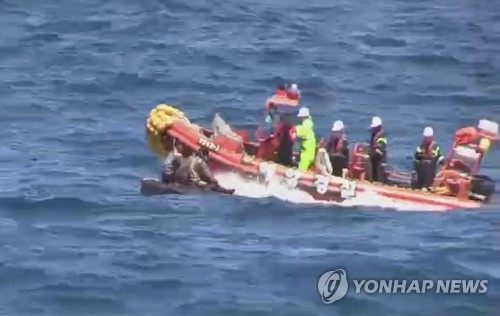 In this file photo, South Korean Coast Guard officers rescue six North Korean sailors in the East Sea on May 27, 2017. They all returned to the North last week. (Yonhap)