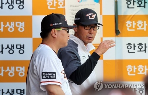In this file photo taken on May 24, 2017, Lee Sang-kun (R), interim manager of the Hanwha Eagles, speaks with a coach during a Korea Baseball Organization regular season game against the Kia Tigers at Hanwha Life Eagles Park in Daejeon. (Yonhap)