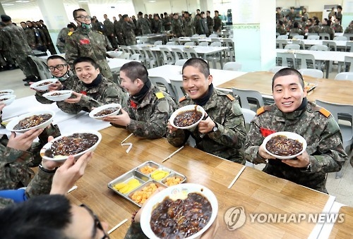 This file photo, taken March 7, 2017, shows a group of new Army conscripts happily holding up dishes of jjajangmyeon, which were provided as a special treat following their hard training. (Yonhap)
