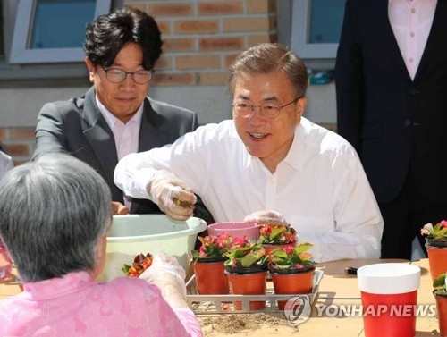 President Moon Jae-in makes pots of flowers with senior citizens at a state-operated nursing home in Seoul on June 2, 2017. (Yonhap)