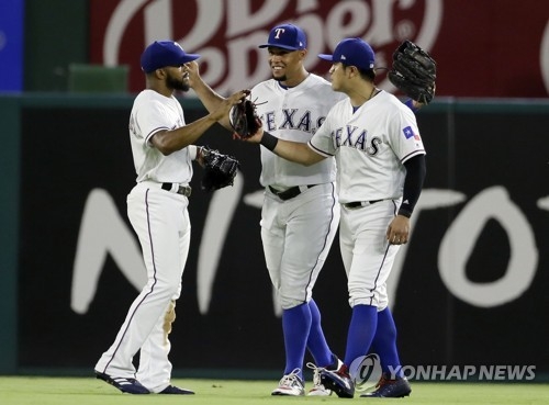 In this Associated Press photo, outfielders of the Texas Rangers -- Delino DeShields, Carlos Gomez and Choo Shin-soo (L to R) -- celebrate their 10-4 victory over the Seattle Mariners at Global Life Park in Arlington in Texas on June 17, 2017. (Yonhap)