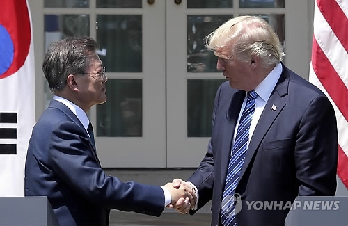 South Korea President Moon Jae-in (L) and U.S. President Donald Trump shake hands after a joint press conference that followed their first summit at the White House on June 30, 2017. (Yonhap)