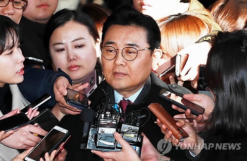 Jun Byung-hun, former senior aide to President Moon Jae-in, is swamped by reporters asking him questions as he appears at the Seoul Central District Prosecutors' Office for questioning over a bribery case on Dec. 4, 2017. (Yonhap) 