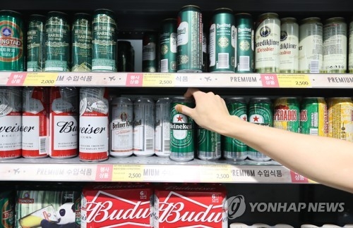 In this file photo taken Aug. 22, 2017, a customer picks up a foreign beer brand from a counter at an outlet in Seoul. (Yonhap)