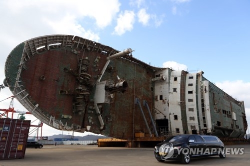 A funeral car passes by the wreck of the Sewol ferry at Mokpo port, 410 kilometers south of Seoul, on Nov. 18, 2017. (Yonhap)