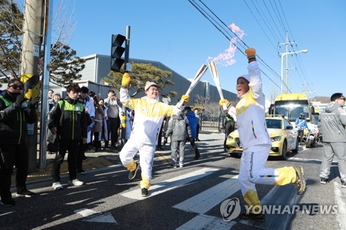 This photo provided by Gumi City Government on Dec. 27, 2017, shows two runners in the Olympic torch relay for the 2018 PyeongChang Winter Olympics in Gumi, North Gyeongsang Province. (Yonhap)