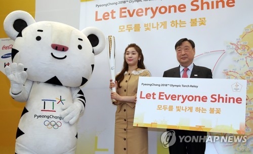 In this file photo taken April 17, 2017, Lee Hee-beom (R), the president of the PyeongChang 2018 Organizing Committee, poses for a photo with former South Korean figure skater Kim Yu-na during a media event for the Olympic torch relay in Seoul. (Yonhap)