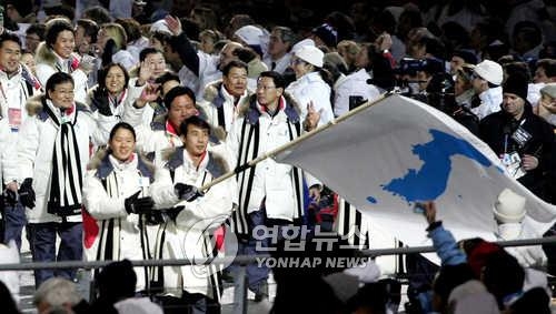 Lee Bo-ra (L) and Han Jong-in carry the flag at the opening ceremony of the 2006 Turin Winter Olympics held on Feb. 10, 2006. (Yonhap file photo)