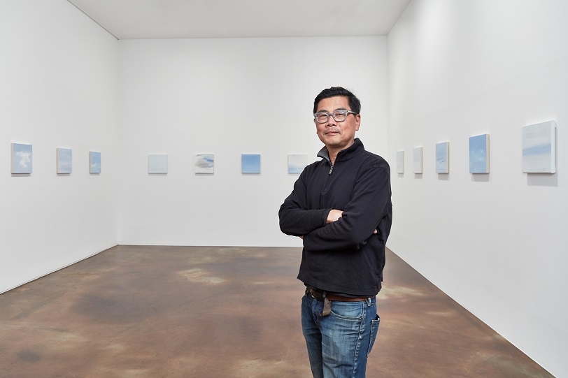 Artist Byron Kim stands in front of his "Sunday Paintings" series in this photo provided by Kukje Gallery in Seoul on Feb.1, 2018. (Yonhap)