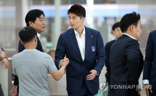South Korea men's national football team head captain Ki Sung-yueng (C) shakes hands with an official at Incheon International Airport in Incheon before departing for his team's pre-World Cup training camp in Austria on June 3, 2018. (Yonhap)