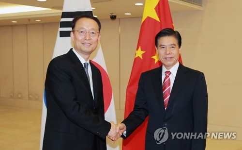 Paik Un-gyu, South Korean minister of trade, industry and energy (L), shakes hands with China's Commerce Minister Zhong Shan (R) during their meeting in Beijing on June 5, 2018, in this photo provided by the Korean ministry. (Yonhap) 