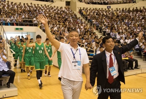 In this Joint Press Corps photo, South Korean men's basketball head coach Hur Jae (L) and North Korean head coach Ri Duk-chol enter Ryugyong Chung Ju-yung Gymnasium in Pyongyang on July 4, 2018, before a mixed-team friendly game. (Yonhap)