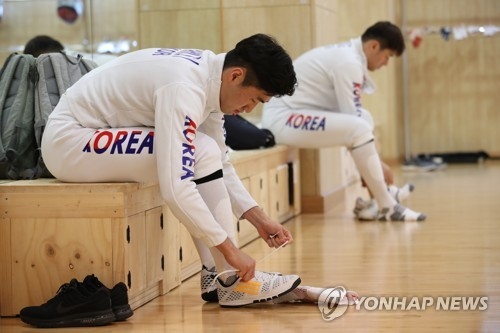 South Korean epee fencer Park Sang-young (foreground) ties his shoes before practice at the Jincheon Training Center in Jincheon, 90 kilometers south of Seoul, on Aug. 6, 2018. Park will compete in the Aug. 18-Sept. 2 Asian Games in Jakarta and Palembang, Indonesia. (Yonhap)