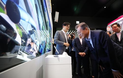 President Moon Jae-in tests a smart media wall using fifth-generation (5G) technology at a research and development complex in Seoul on May 17, 2018. (Yonhap)