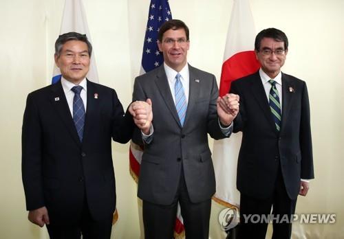 U.S. Secretary of Defense Mark Esper (C) holds the hands of South Korea's Defense Minister Jeong Kyeong-doo (L) and his Japanese counterpart, Taro Kono, ahead of their trilateral talks in Bangkok on Nov. 17, 2019. (Yonhap)