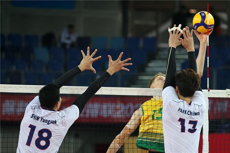 In this photo provided by FIVB on Jan. 7, 2020, Park Chul-woo of South Korea (R) attempts to block Samuel Walker of Australia (C) during their Pool B match of the Asian Olympic men's volleyball qualification tournament at Jiangmen Sports Center Gymnasium in Jiangmen, China. (PHOTO NOT FOR SALE) (Yonhap)