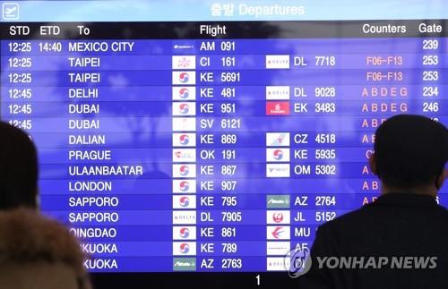 This undated file photo shows travelers looking at flight details at Incheon International Airport, west of Seoul. (Yonhap)