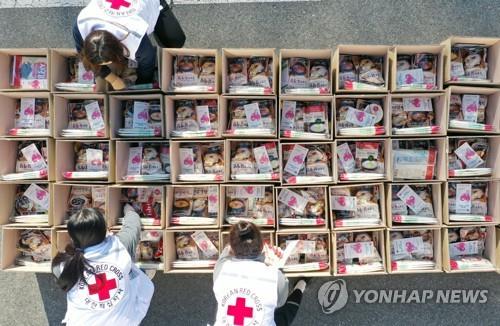 Employees of the National Red Cross prepare emergency relief kits packed with basic necessities like instant food in the southwestern city of Gwangju on March 6, 2020, for delivery to impoverished people experiencing difficulties amid the spread of the new coronavirus. (Yonhap)