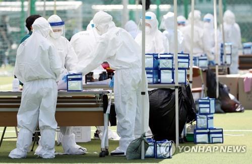 Health workers prepare to carry out COVID-19 tests at a makeshift clinic set up in front of a ward office in Incheon, west of Seoul, on May 13, 2020, as a coronavirus patient was found to have visited a church in the ward. (Yonhap) 