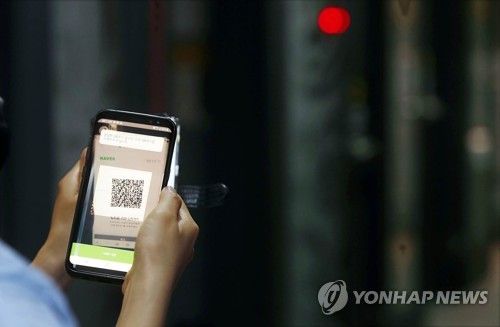 A local government official check whether QR code-based logs are working at a karaoke establishment in Gwangju's Buk Ward, southwestern South Korea, on June 9, 2020, in this photo provided by the ward office. (PHOTO NOT FOR SALE) (Yonhap)