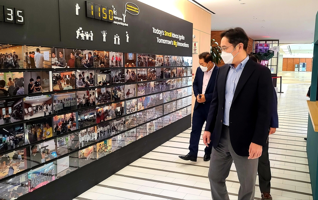 In this photo provided by Samsung Electronics Co. on July 6, 2020, Samsung Electronics Vice Chairman Lee Jae-yong (R) looks at photos of the company's in-house startup incubation program C-Lab in Suwon, south of Seoul. (PHOTO NOT FOR SALE) (Yonhap)
