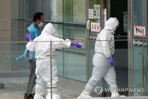 A medical worker takes a man infected with the new coronavirus to a hospital in the southwestern city of Gwangju on July 7, 2020. Police officers took the man in his 60s into custody at a construction site in the nearby town of Yeonggwang after he went into hiding with his smartphone turned off. (Yonhap)