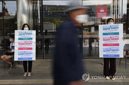 Doctors at Seoul National University Hospital in Seoul hold signs on Aug. 23, 2020, in protest of the government's plan to increase medical school admission quotas. (Yonhap)