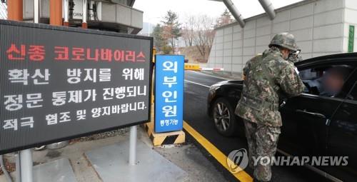 A service member checks the temperature of a driver at the entrance of the Armed Forces General Hospital in Seongnam, south of Seoul, on Feb. 21, 2020. (Yonhap)