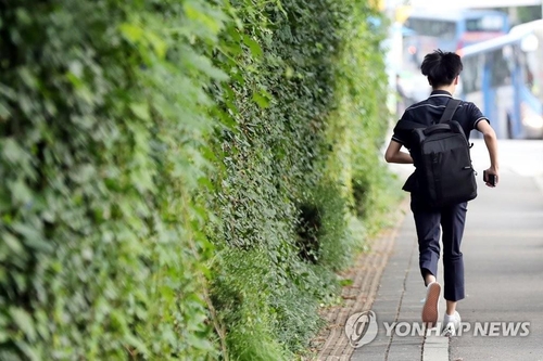 A student runs toward his school in Incheon, South Korea, on Sept. 21, 2020, as his school reopened after about a month amid a slowdown in new coronavirus cases. (Yonhap) 