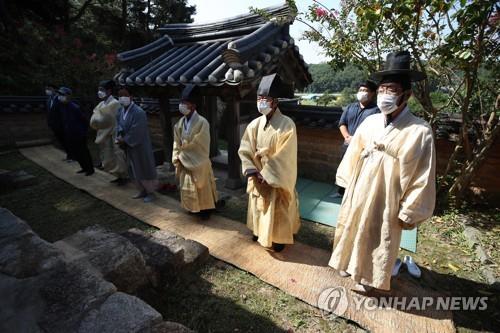 Members of the Byun family perform a traditional ceremony in honor of their ancestors at an old traditional mansion in Andong, North Gyeongsang Province, on the Chuseok autumn harvest holiday on Oct. 1, 2020, wearing protective masks and standing apart from each other amid the COVID-19 pandemic. (Yonhap)