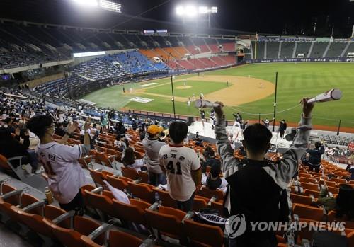 Fans attend a Korea Baseball Organization regular season game between the Hanwha Eagles and the Doosan Bears at Jamsil Stadium in Seoul on Oct. 13, 2020. The government eased social distancing rules over the coronavirus, allowing sports leagues to admit crowds of up to 30 percent of stadium capacities. (Yonhap)